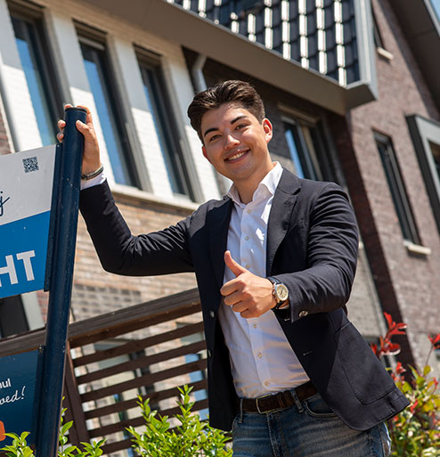 Makelaar voor een preview woning met duim omhoog